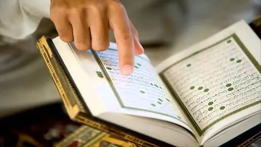 Teacher guiding a Quran reading detail